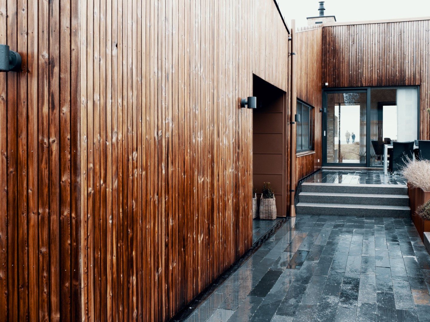 Bilde av inngangsparti på hus med mye treverk.