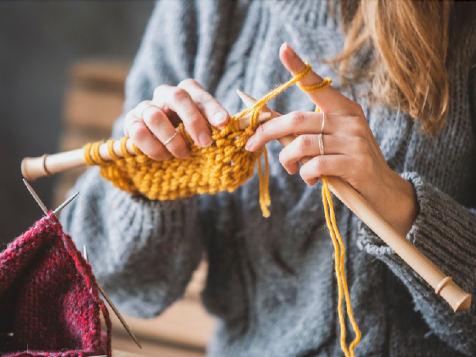 Dame som strikker på store pinner