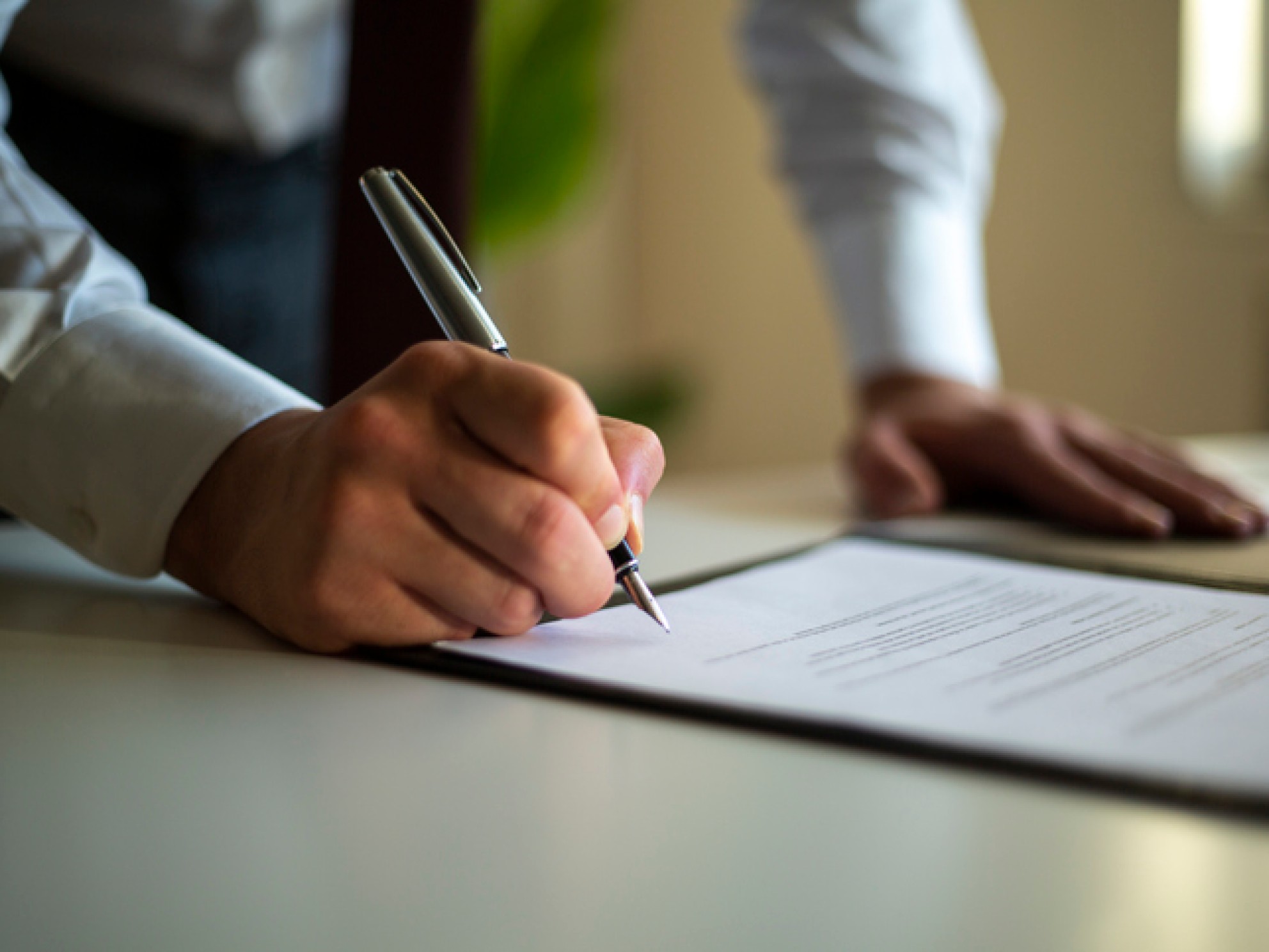 Mann signerer avtale