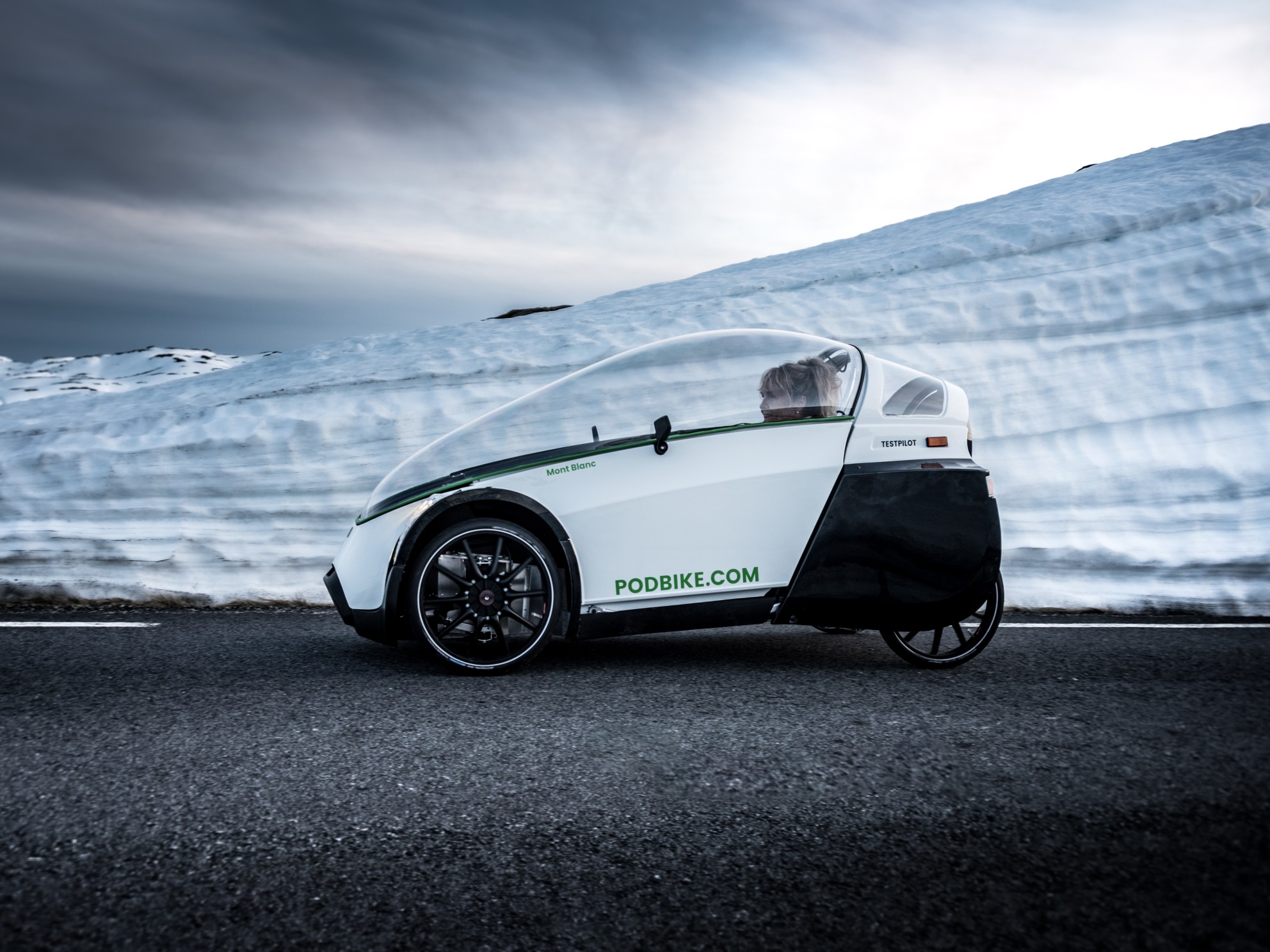 sykkelbil på b\vei med snø i bakgrunnen