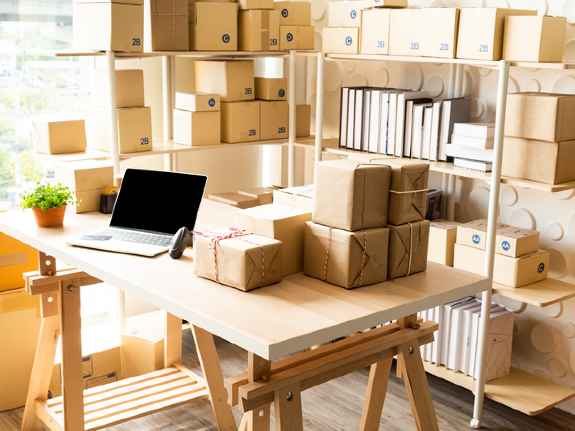  Kontor med bærbar datamaskin og strekkodeskanner på produktets skrivebord med brune bokser på bordet