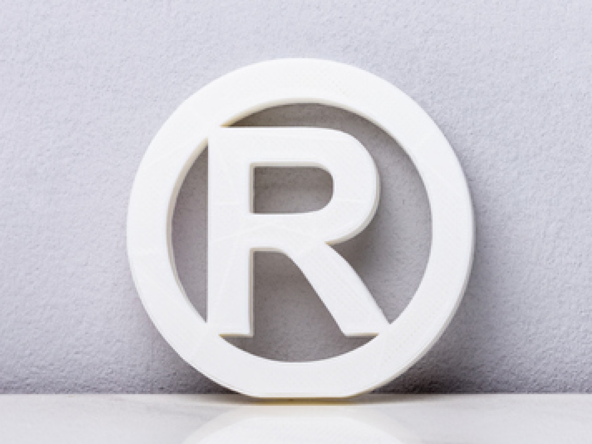 R i sirkel som er symbolet for registrert varemerke