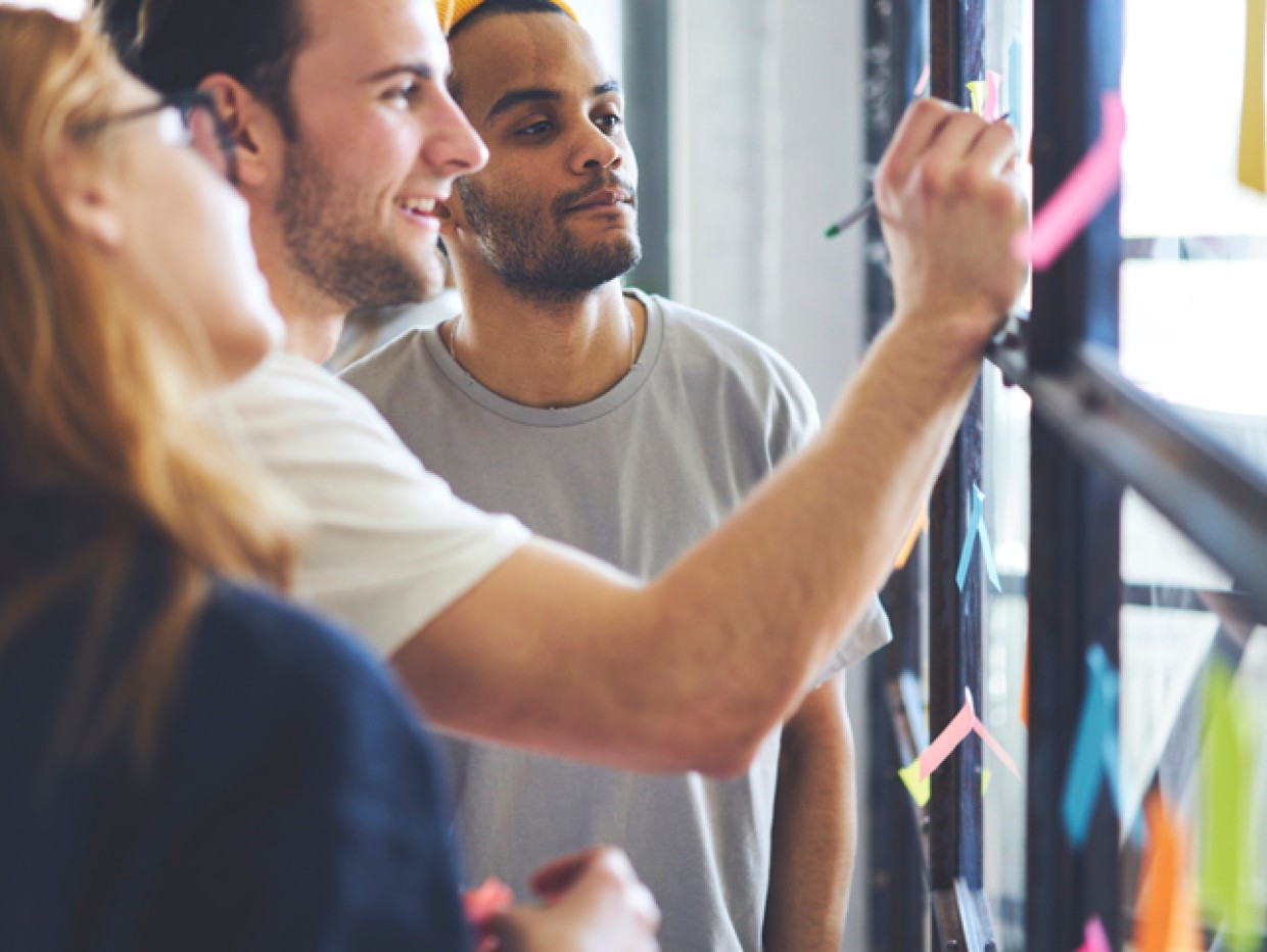 Personer på jobb noterer på post-it lapper
