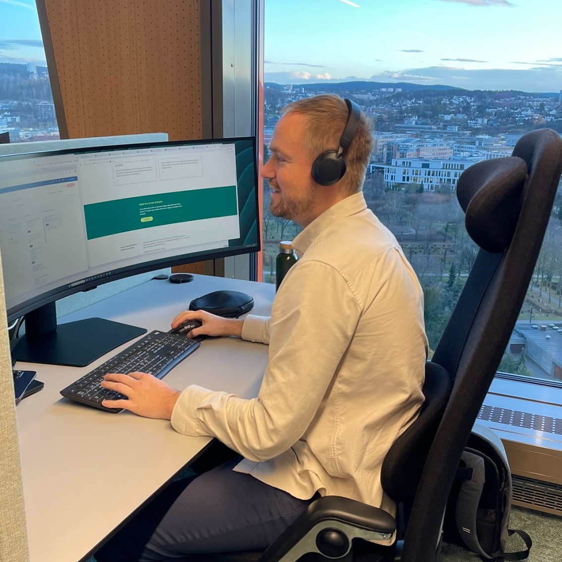 Mann ved PC snakker i telefonen