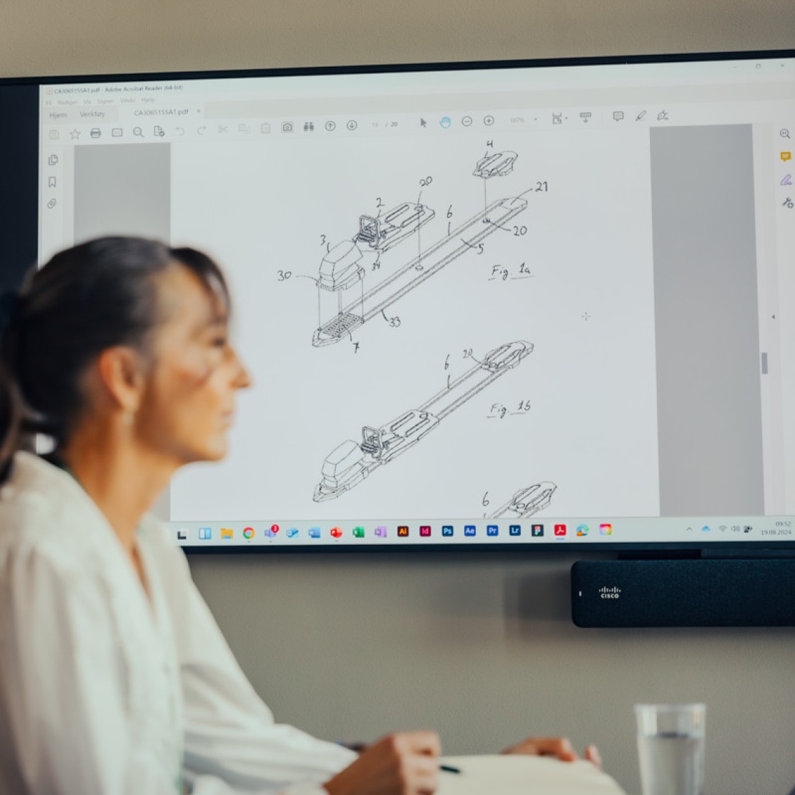 Patenttegning vist på skjerm bak en person