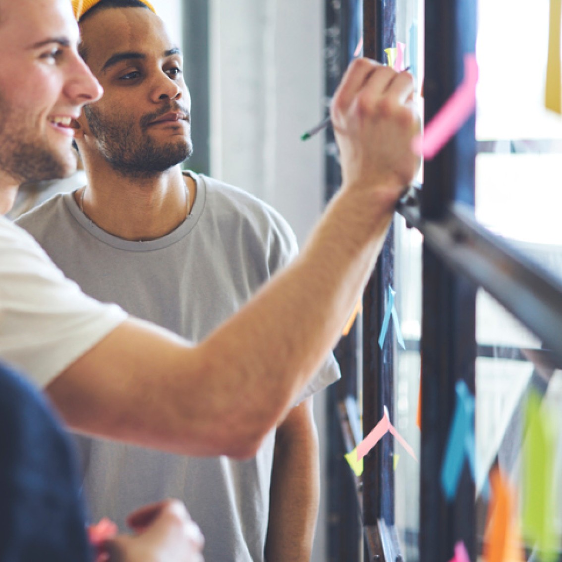 Personer på jobb noterer på post-it lapper