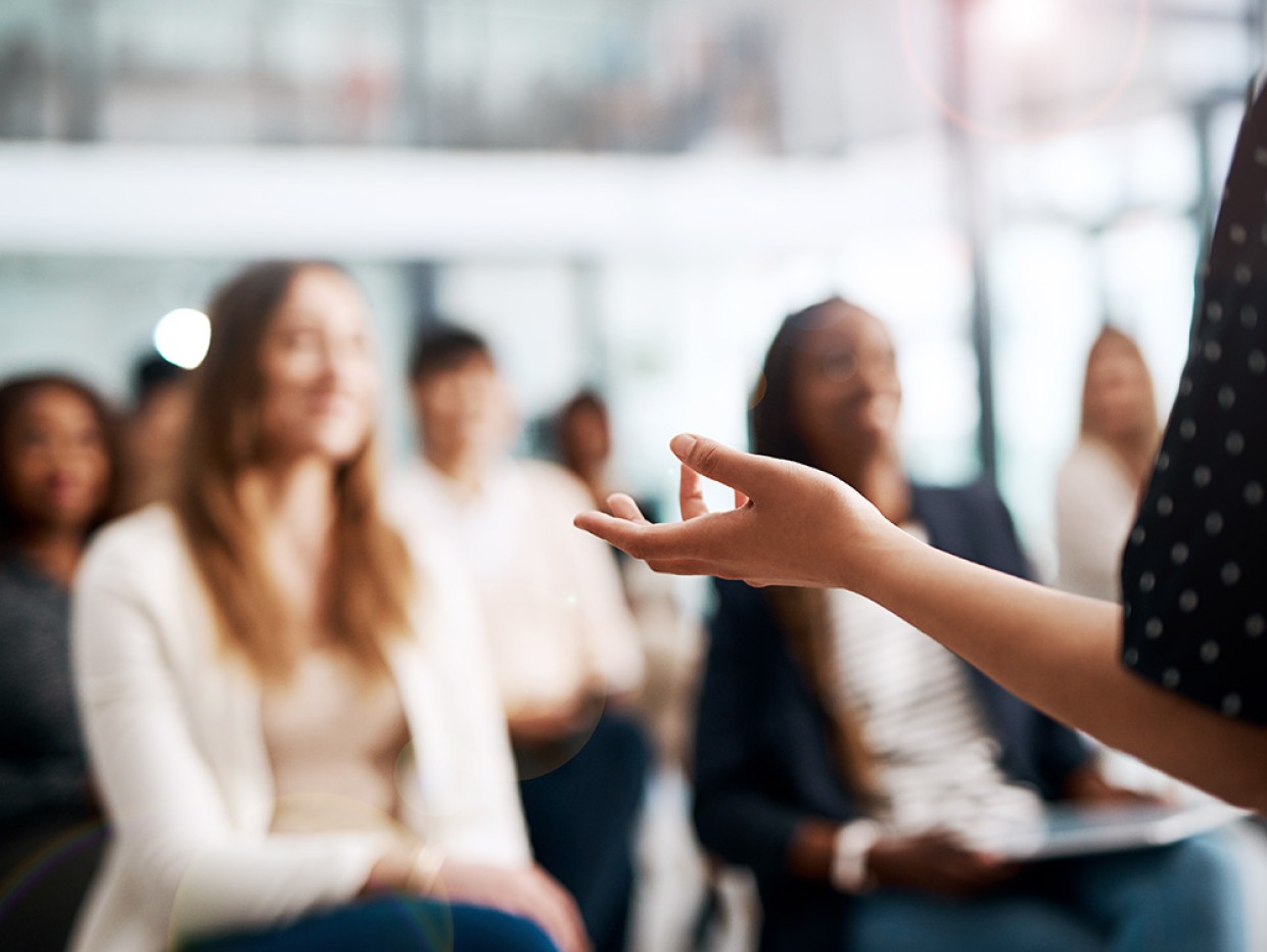 Gruppe-mennesker-hører-på-foredrag