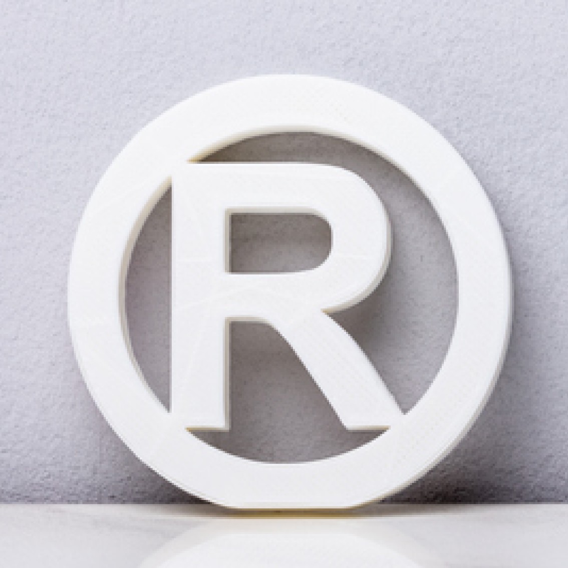 R i sirkel som er symbolet for registrert varemerke