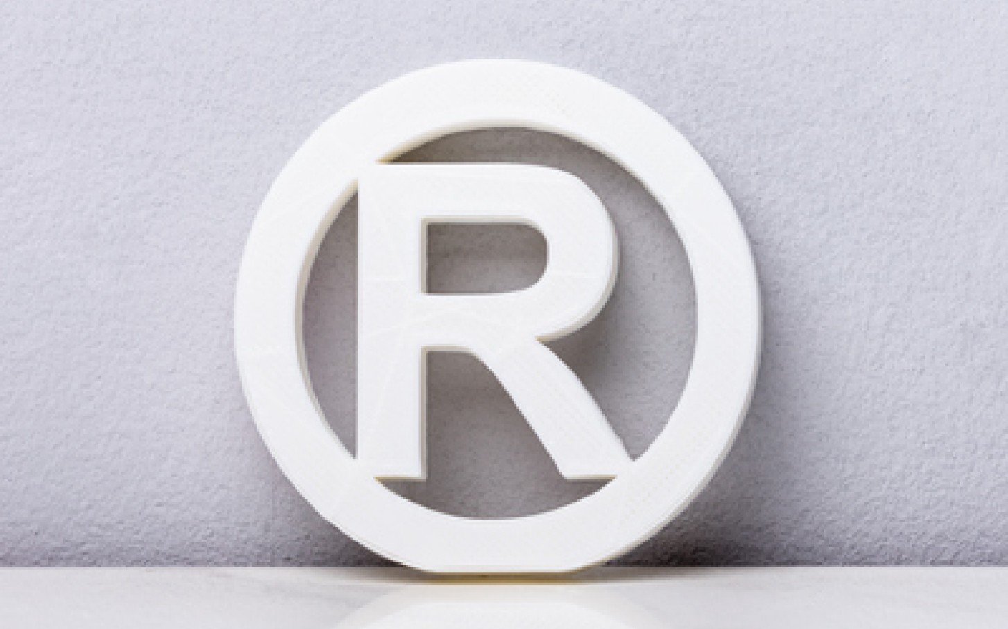 R i sirkel som er symbolet for registrert varemerke