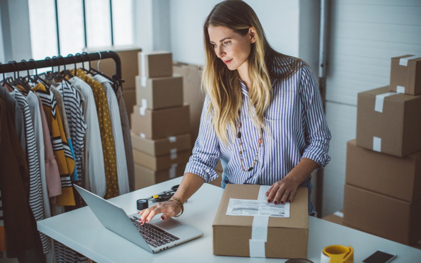 Kvinne pakker varer etter bestilling fra nettbutikk